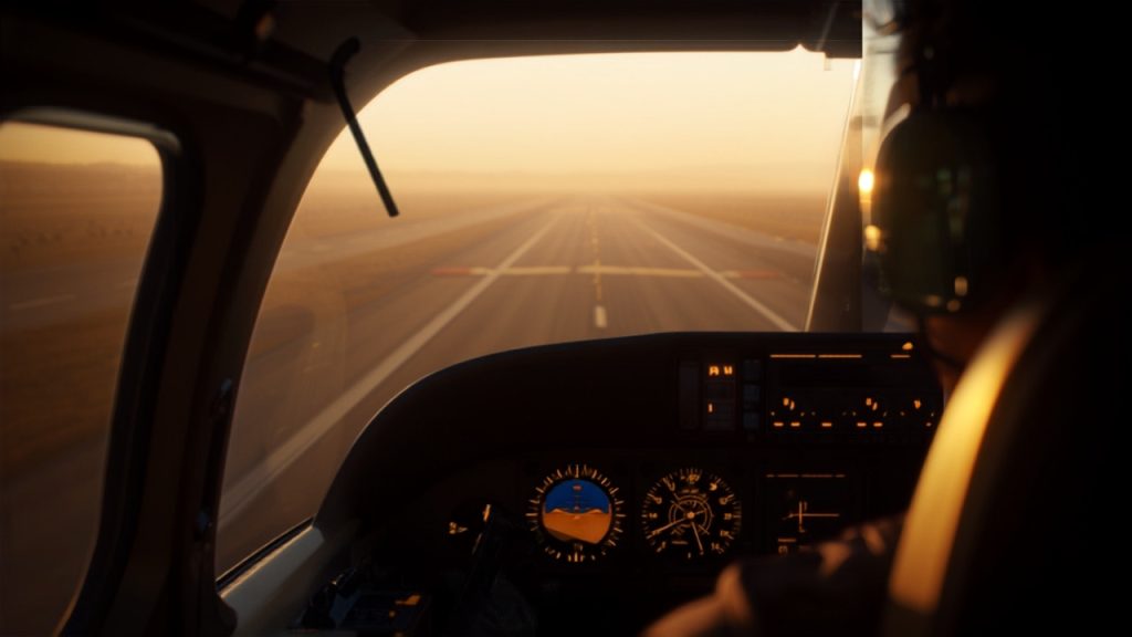 Commercial airline pilot in cockpit reviewing flight instruments before departure